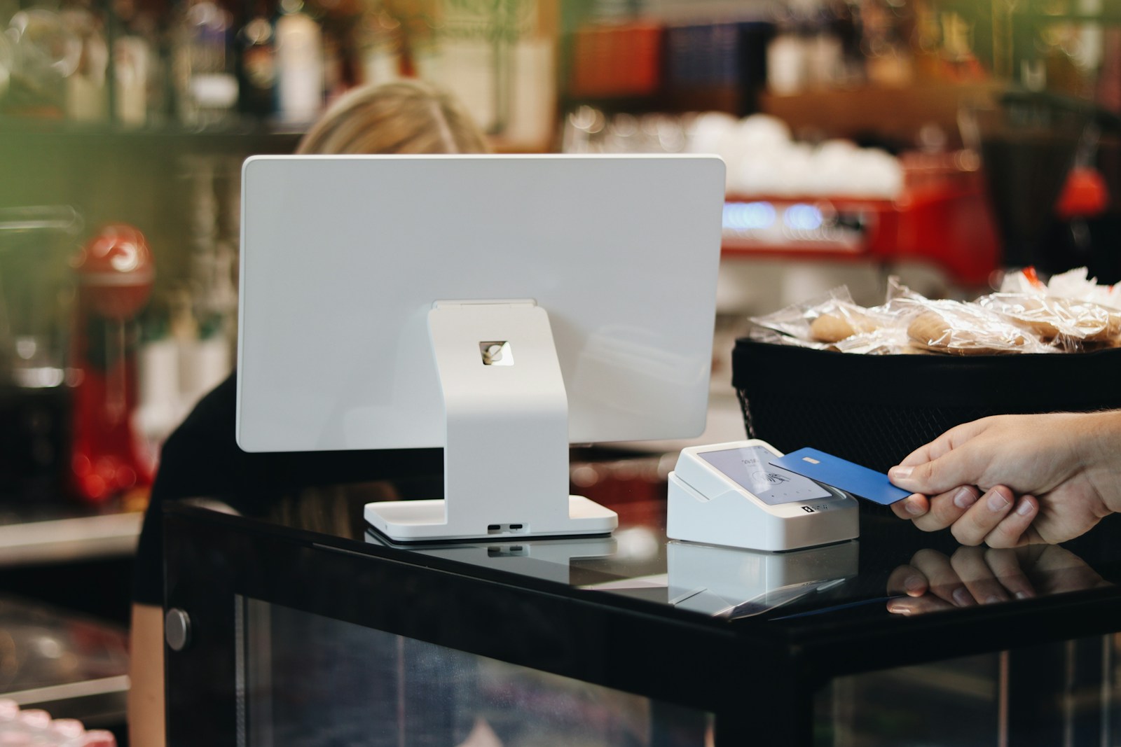 A person holding a credit card in front of a computer